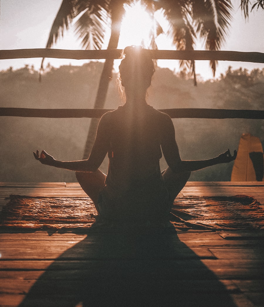 A person meditating cross-legged at sunset